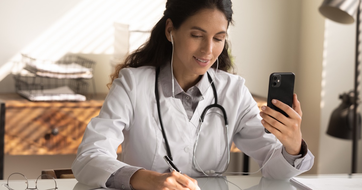 A doctor uses a smartphone to speak with a patient.